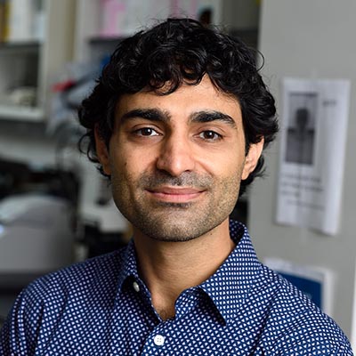 Headshot of Reza Kalhor with laboratory setting in the background