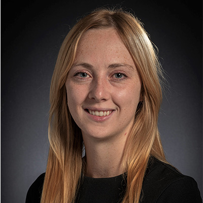 Headshot of Ashley Kiemen. She has blue eyes and long blonde hair and is wearing a black crew neck shirt.